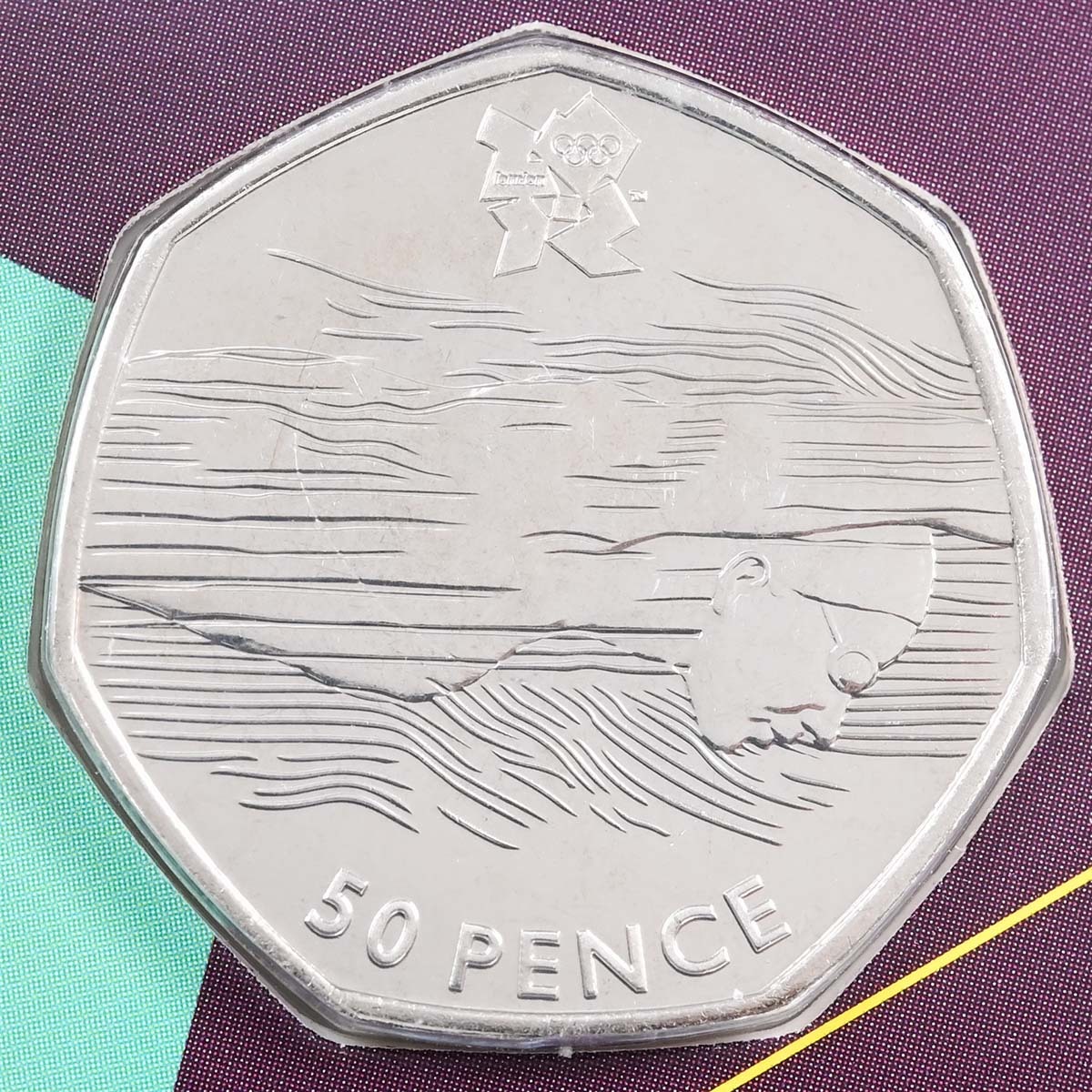 Brilliant Uncirculated 2011 Fifty Pence Aquatics Coin, featured in the London 2012 Sports Collection Coin reverse featuring an olympic shooter designed in an open public competition by Jonathan Olliffe